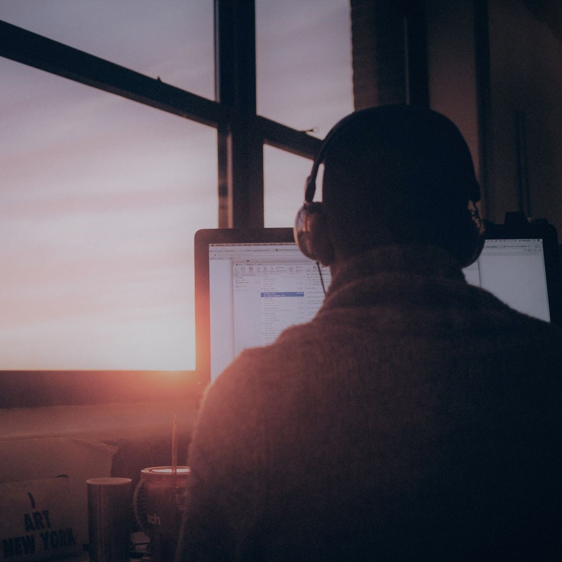 Das Bild zeigt eine männliche Person, die mit aufgesetzten Kopfhörern vor einem PC sitzt. Zu sehen ist nur die Rückansicht der Person. (Quelle: simon-abrams-k_T9Zj3SE8k/Unsplash) Das Bild zeigt eine männliche Person, die mit aufgesetzten Kopfhörern vor einem PC sitzt. Zu sehen ist nur die Rückansicht der Person.