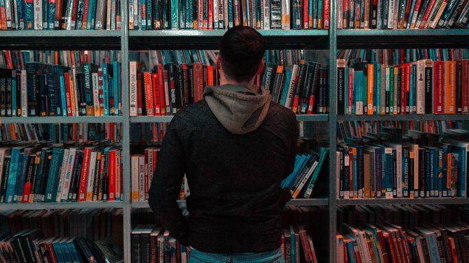 Das Bild zeigt einen Mann in einer Bibliothek (Quelle: Photo by Matthew Feeney on Unsplash) Das Bild zeigt einen Mann in einer Bibliothek