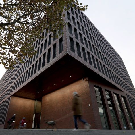 Die Aufnahme vom 12. November 2019 zeigt Passanten vor dem Liegenschaftsgebäude des ZNAF in Berlin.   (Quelle: picture alliance/AP Photo | Michael Sohn) Die Aufnahme vom 12. November 2019 zeigt Passanten vor dem Liegenschaftsgebäude des ZNAF in Berlin.