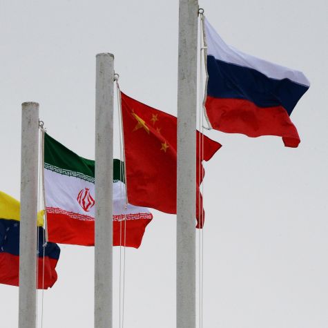 Die Aufnahme zeigt die im Wind wehenden Flaggen der Staaten Iran, China und Russland 