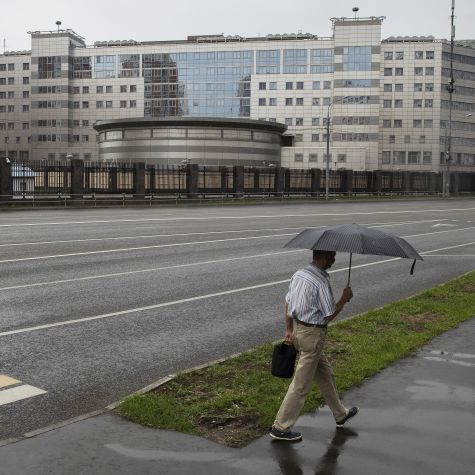 Die Aufnahme zeigt einen Mann mit Regenschirm, der an der Liegenschaft des militärischen Auslandsnachrichtendienstes (GRU) der Russischen Föderation in Moskau vorbeigeht.