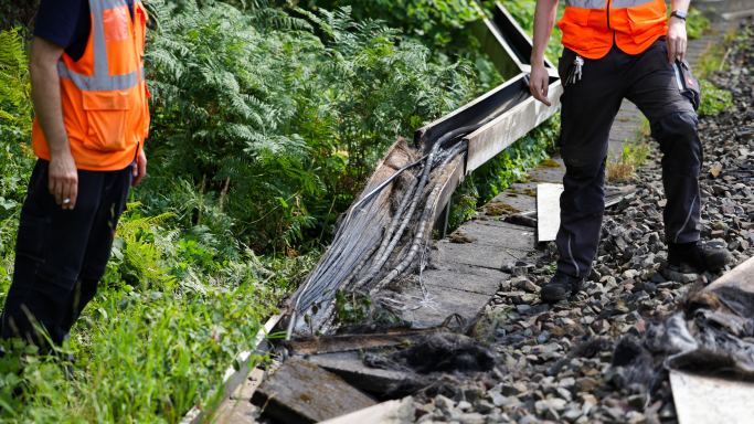 Mitarbeiter der Deutschen Bahn stehen neben einer Bahnstrecke, an der ein Feuer in einem Kabeltunnel gelegt wurde (Quelle: Christoph Reichwein/dpa/picture alliance) Mitarbeiter der Deutschen Bahn stehen neben einer Bahnstrecke, an der ein Feuer in einem Kabeltunnel gelegt wurde