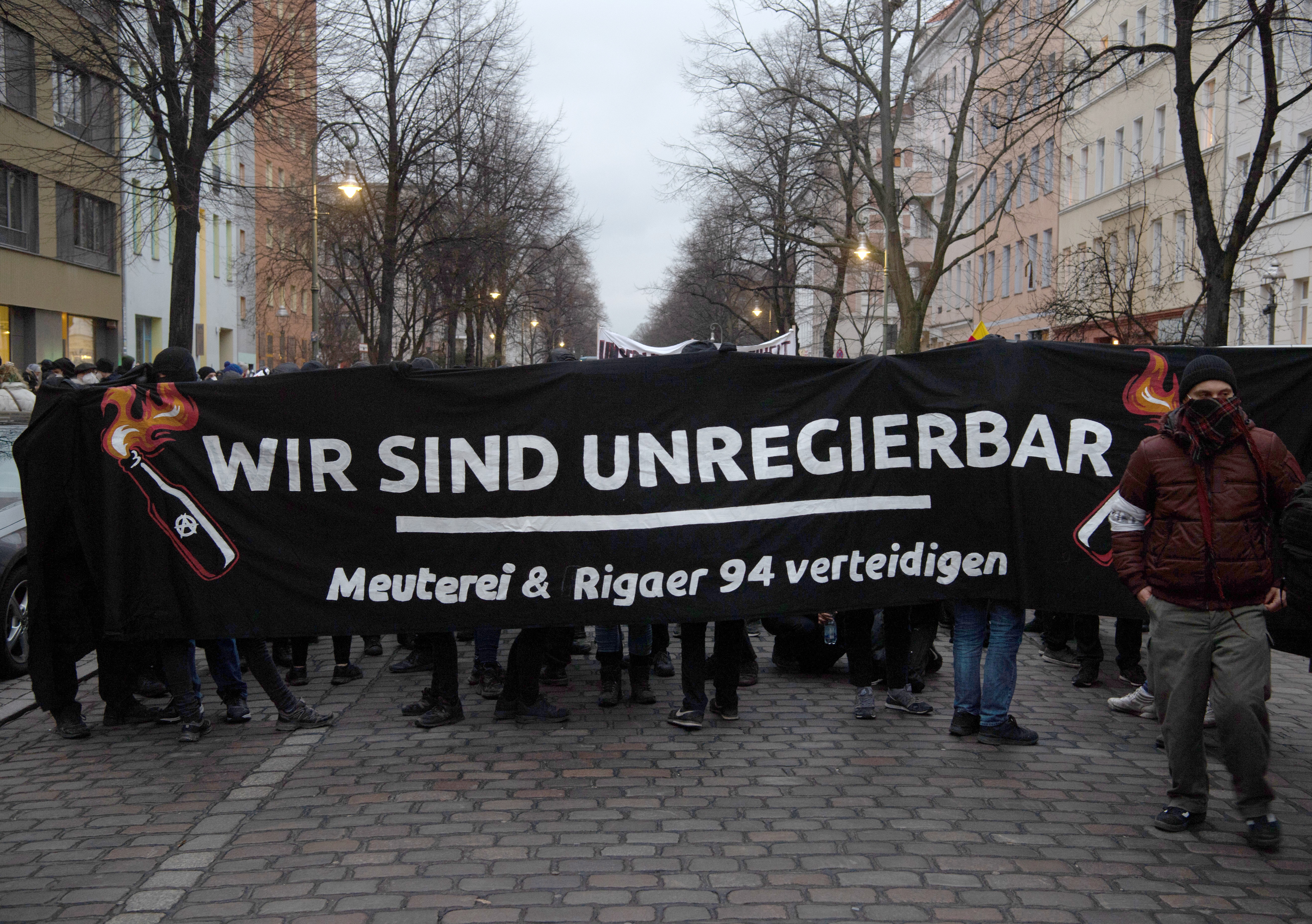 Demonstrierende Personen mit einem schwarzen Transparent mit der Aufschrift "wir sind unregierbar" am 23.03.2021