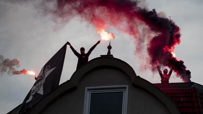 Demonstranten zünden während einer Demonstration gegen die geplante Räumung der Szene-Kneipe Syndikat auf einem Dach Rauchpatronen. (Quelle: picture alliance/dpa | Fabian Sommer) Demonstranten zünden während einer Demonstration gegen die geplante Räumung der Szene-Kneipe Syndikat auf einem Dach Rauchpatronen.