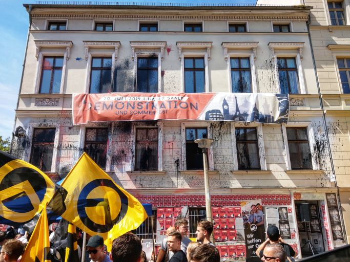 Das Bild zeigt Personen mit Fahnen der Identitären Bewegung vor einem Gebäude (Quelle: picture alliance / ZUMAPRESS.com | Sachelle Babbar) Das Bild zeigt Personen mit Fahnen der Identitären Bewegung vor einem Gebäude