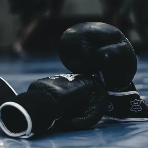 Die Aufnahme zeigt zwei auf dem Boden liegende Boxhandschuhe (Quelle: Photo by Bogdan Yukhymchuk on Unsplash) Die Aufnahme zeigt zwei auf dem Boden liegende Boxhandschuhe