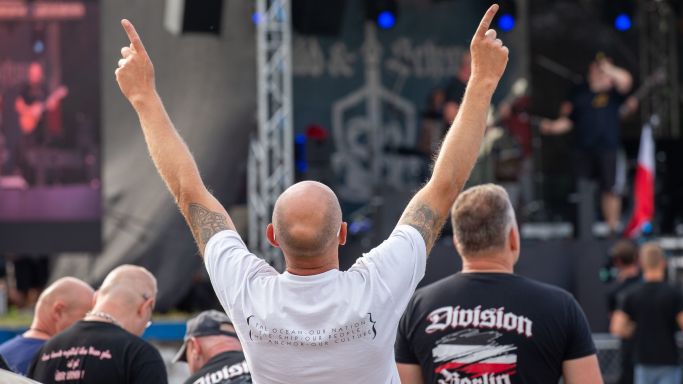 Die Aufnahme vom 22. Juni 2019 zeigt einen Mann, der die Arme zur Musik bewegt, die auf der Bühne des Rechtsrockfestivals "Schild & Schwert" in Ostritz (Sachsen) gespielt wird. (Quelle: picture alliance/dpa/dpa-Zentralbild | Daniel Schäfer) Die Aufnahme vom 22. Juni 2019 zeigt einen Mann, der die Arme zur Musik bewegt, die auf der Bühne des Rechtsrockfestivals "Schild & Schwert" in Ostritz (Sachsen) gespielt wird.