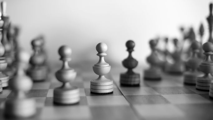 Die Aufnahme zeigt ein Schachbrett, auf dem sich weiße und schwarze Figuren in einer Partie gegenüber stehen (Quelle: Photo by Petr Petr on Unsplash) Die Aufnahme zeigt ein Schachbrett, auf dem sich weiße und schwarze Figuren in einer Partie gegenüber stehen