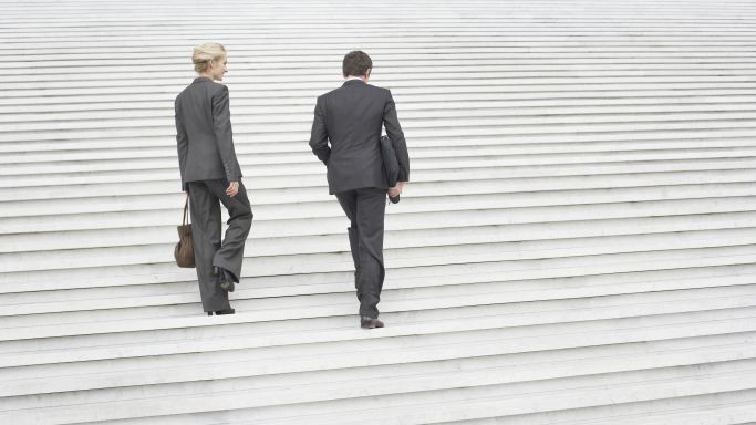 Zwei Geschäftsleute gehen eine Treppe hinauf