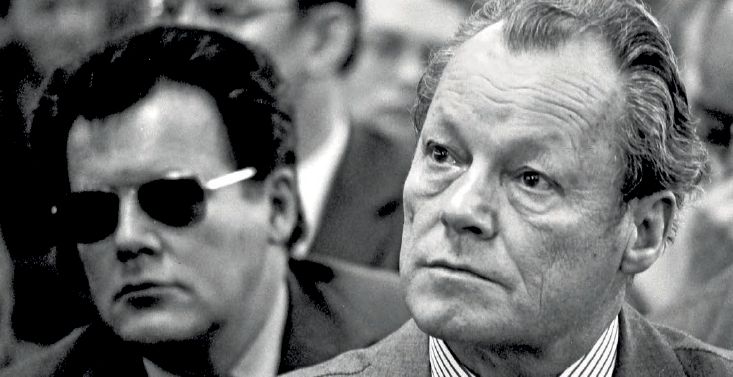 DDR-Spion Günter Guillaume (links) neben dem damaligen Bundeskanzler Willy Brandt bei einer Veranstaltung 1974. (Quelle: picture alliance / SZ Photo | Fritz Rust) DDR-Spion Günter Guillaume (links) neben dem damaligen Bundeskanzler Willy Brandt bei einer Veranstaltung 1974.