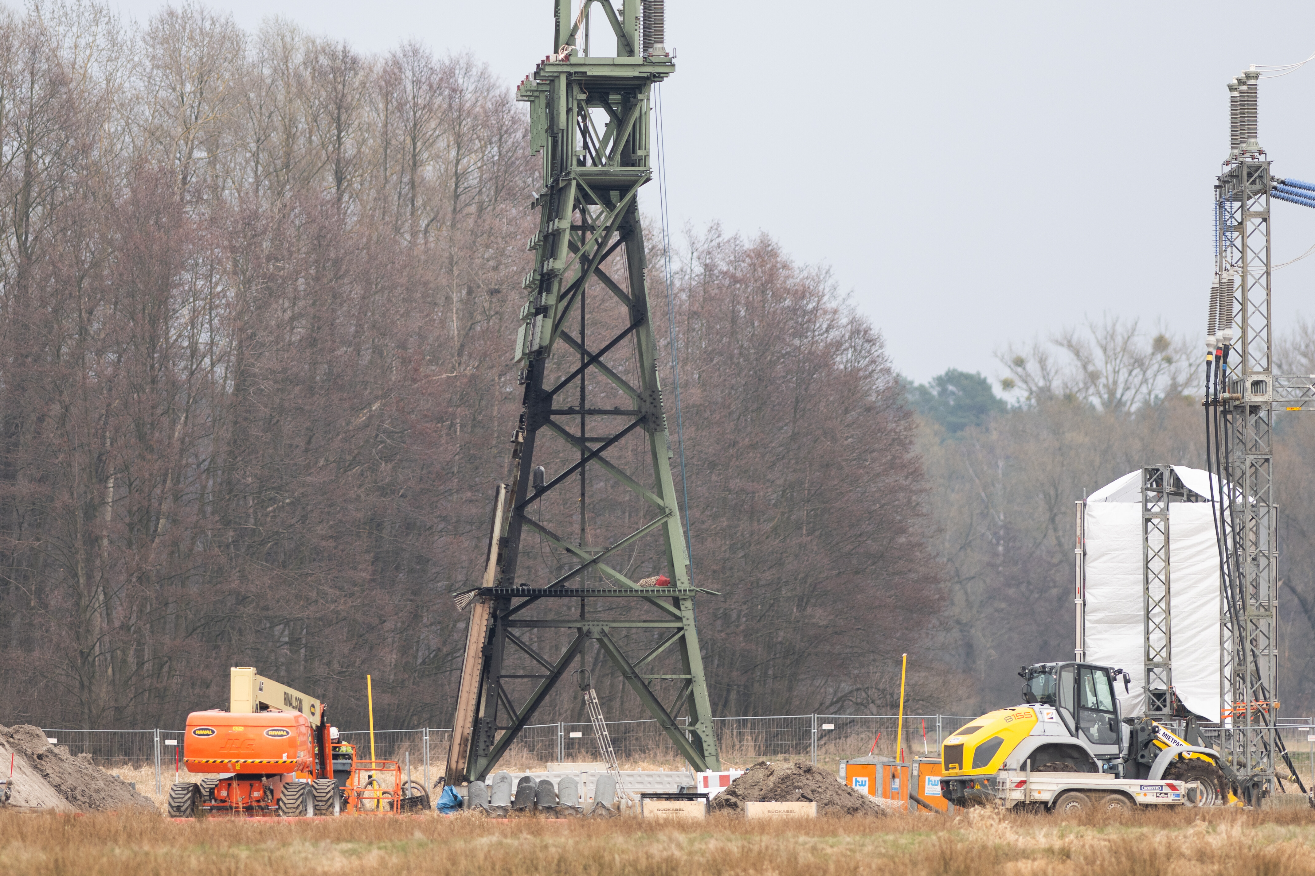 Ein Strommast mit Brandspuren steht auf einem Feld (Quelle: Christophe Gateau/picture alliance) Ein Strommast mit Brandspuren steht auf einem Feld