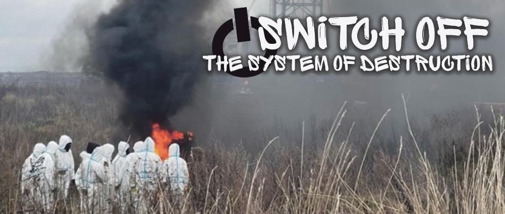 Die Aufnahme zeigt den Schriftzug „Switch off - The System of Destruction“ mit vermummten Personen im Hintergrund Die Aufnahme zeigt den Schriftzug „Switch off - The System of Destruction“ mit vermummten Personen im Hintergrund