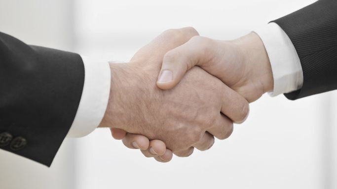 Two businessmen shake hands (Source: Westend61/VEM/picture alliance) Two businessmen shake hands