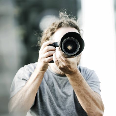 The shot shows a male person taking a photo with a reflex camera. (Source: Westend61/picture alliance) The shot shows a male person taking a photo with a reflex camera.