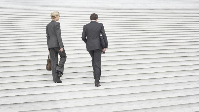Two businessmen walking up a staircase. (Source: Sam Edwards / Getty Images ) Two businessmen walking up a staircase.