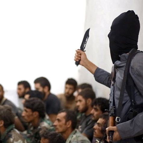 The undated image, published on the Internet on August 27, 2014, shows an IS fighter with a knife and an automatic weapon next to captured Syrian soldiers in Raqqa, Syria. (Source: AP Photo/picture alliance) The undated image, published on the Internet on August 27, 2014, shows an IS fighter with a knife and an automatic weapon next to captured Syrian soldiers in Raqqa, Syria.